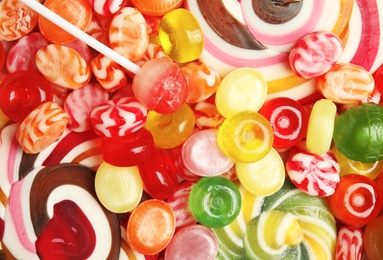 Photo of Different delicious colorful candies as background, top view