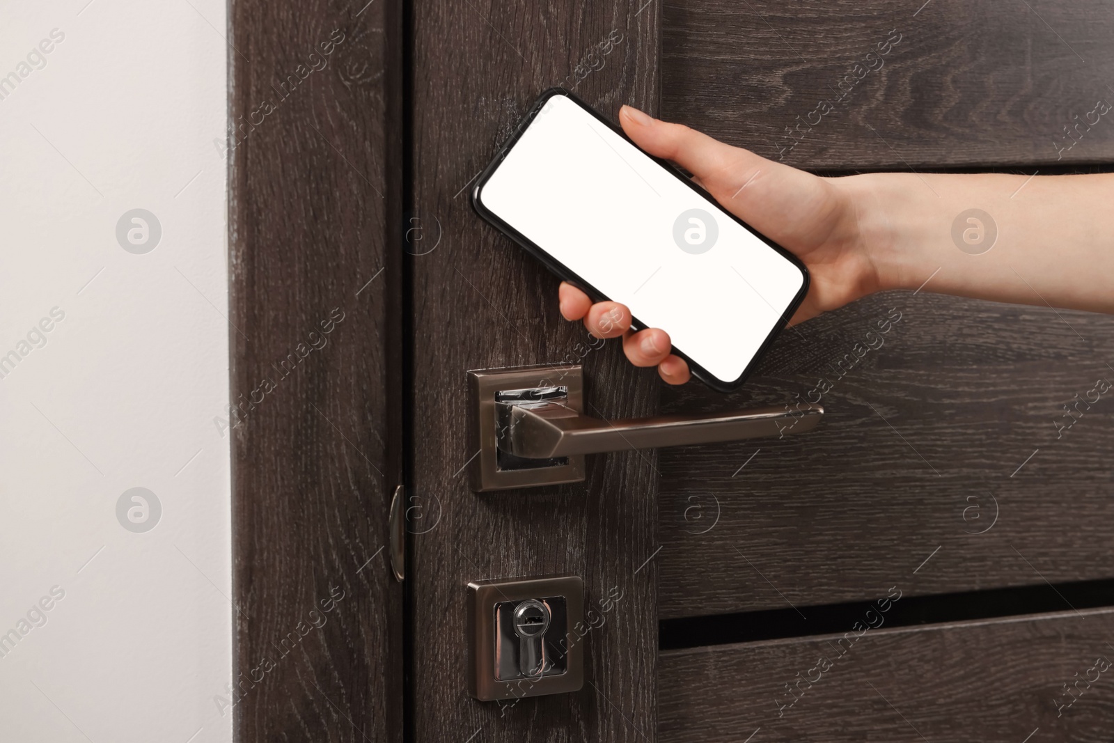 Photo of Woman unlocking door using smartphone, closeup view