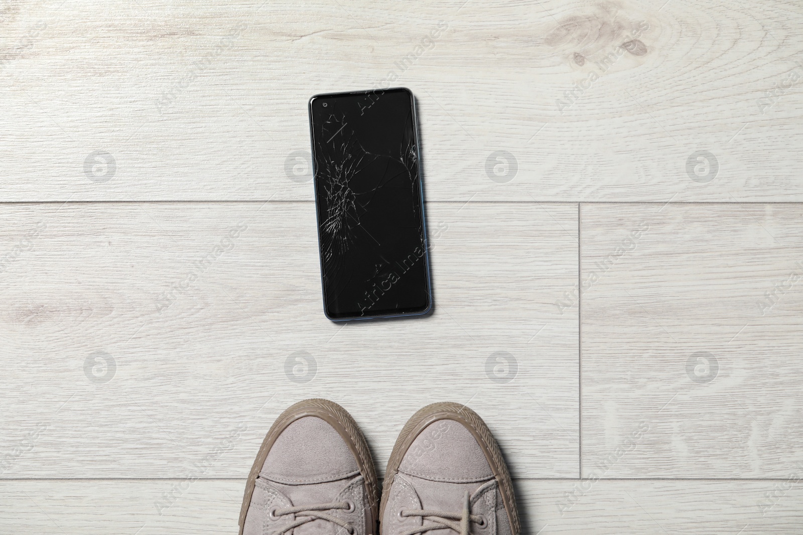 Photo of Woman near dropped smartphone on floor, top view. Device repairing