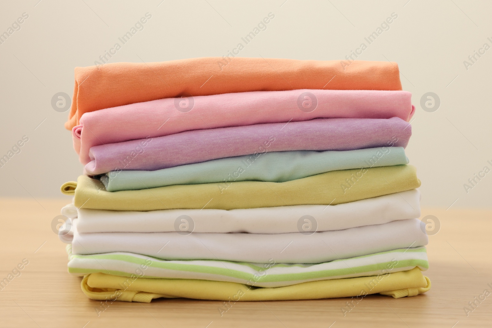 Photo of Stack of clean clothes on wooden table