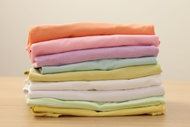 Photo of Stack of clean clothes on wooden table