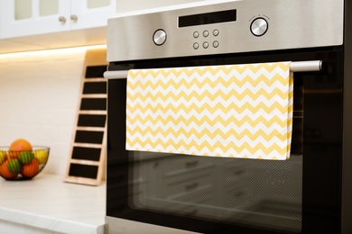 Photo of Clean towel on stove door in kitchen, closeup