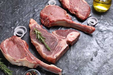 Fresh raw beef cuts and different spices on grey textured table