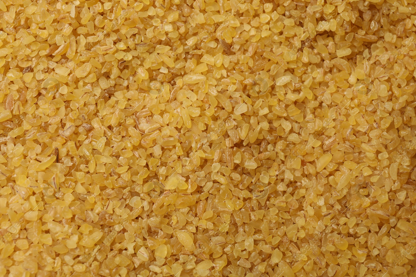Photo of Pile of raw bulgur as background, top view
