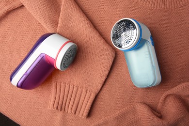 Photo of Modern fabric shaver on sweater with lint, flat lay