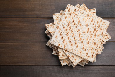 Photo of Stack of matzos on wooden table, top view. Space for text