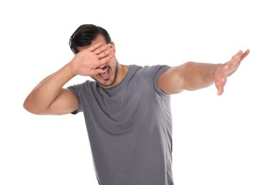 Photo of Young man being blinded and covering eyes with hand on white background