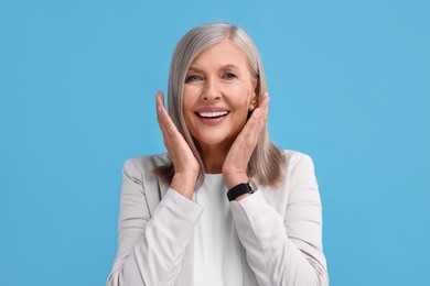 Photo of Portrait of emotional middle aged woman on light blue background