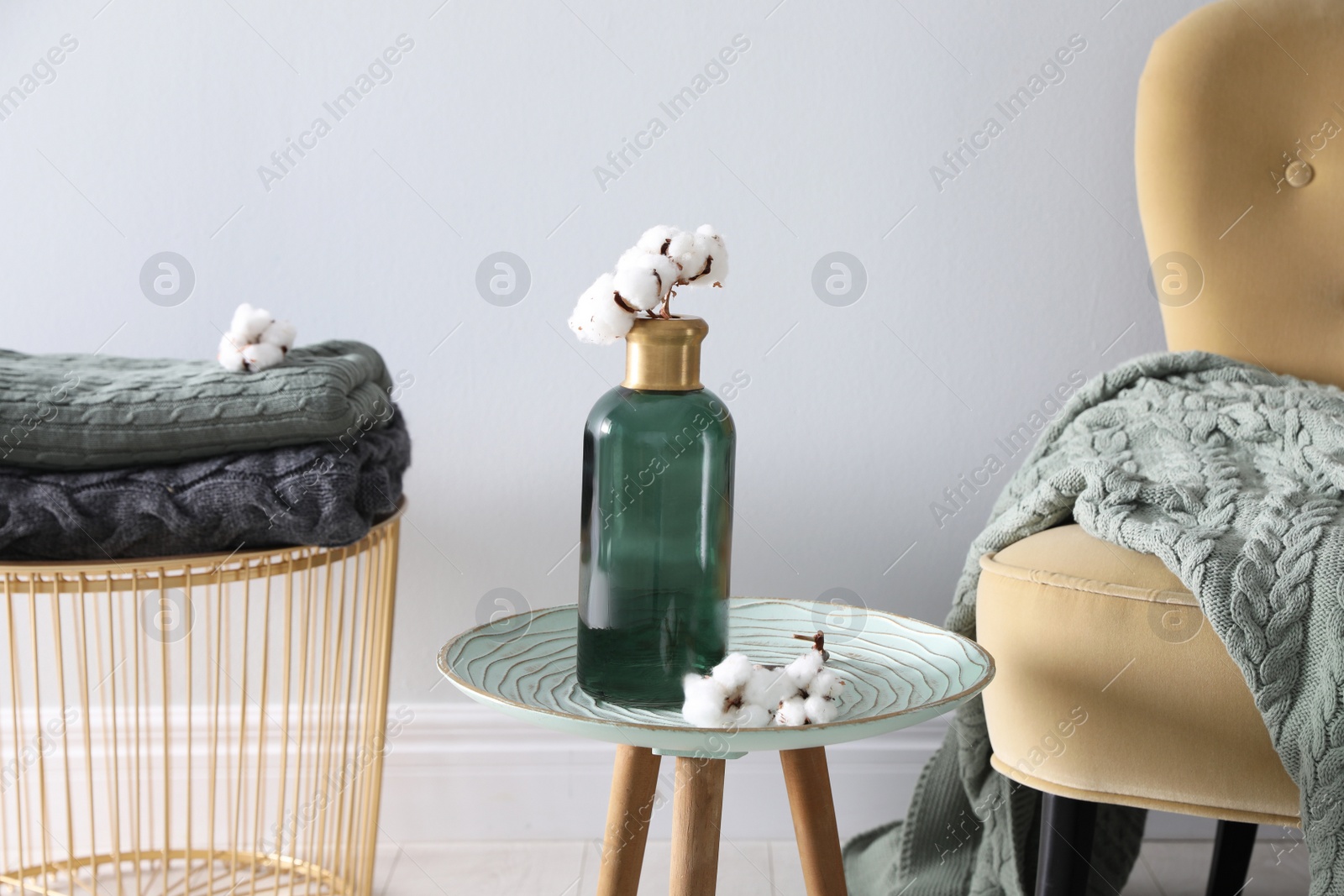 Photo of Soft blankets on armchair and coffee table in room. Home interior