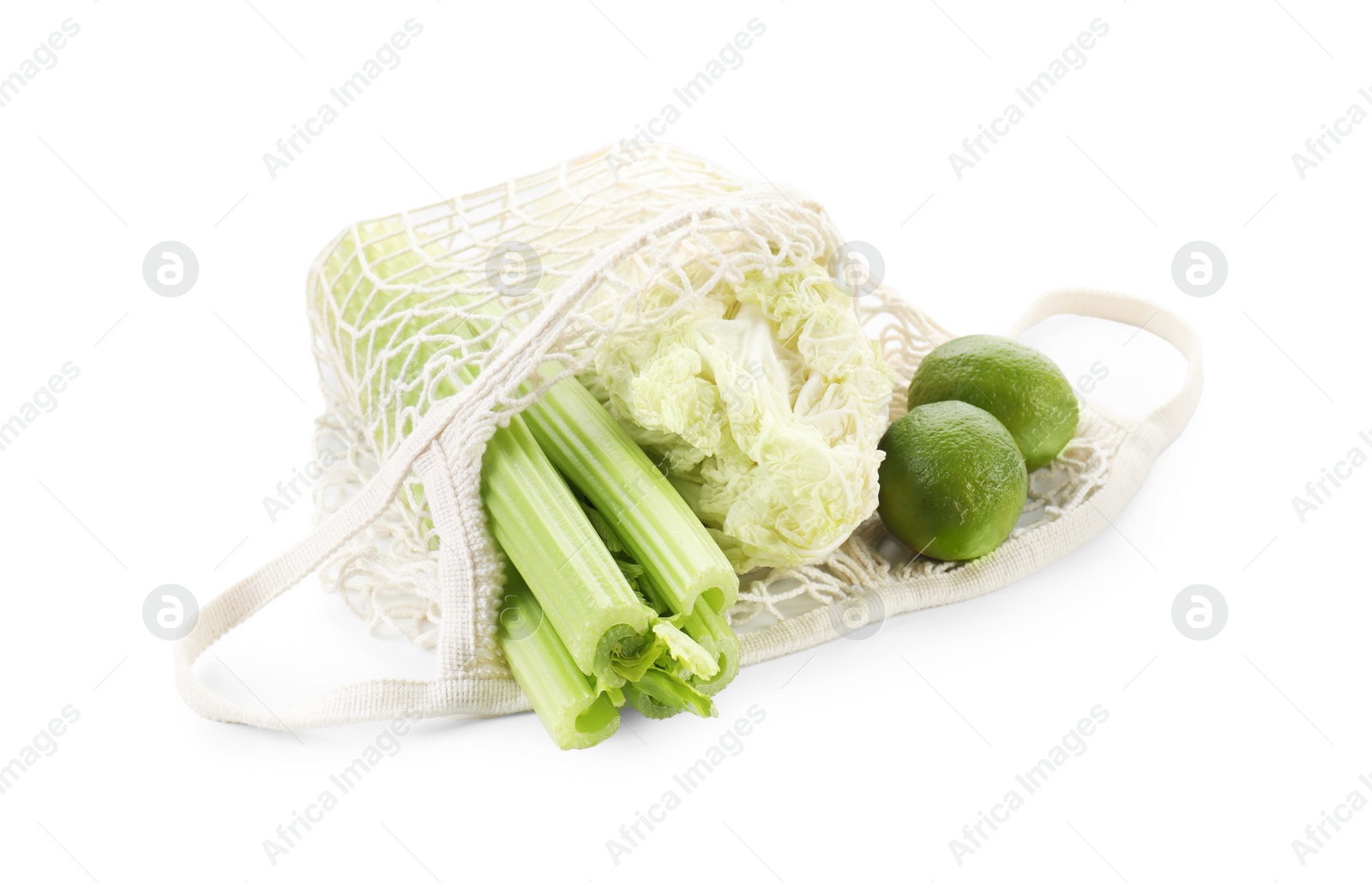 Photo of String bag with different vegetables isolated on white