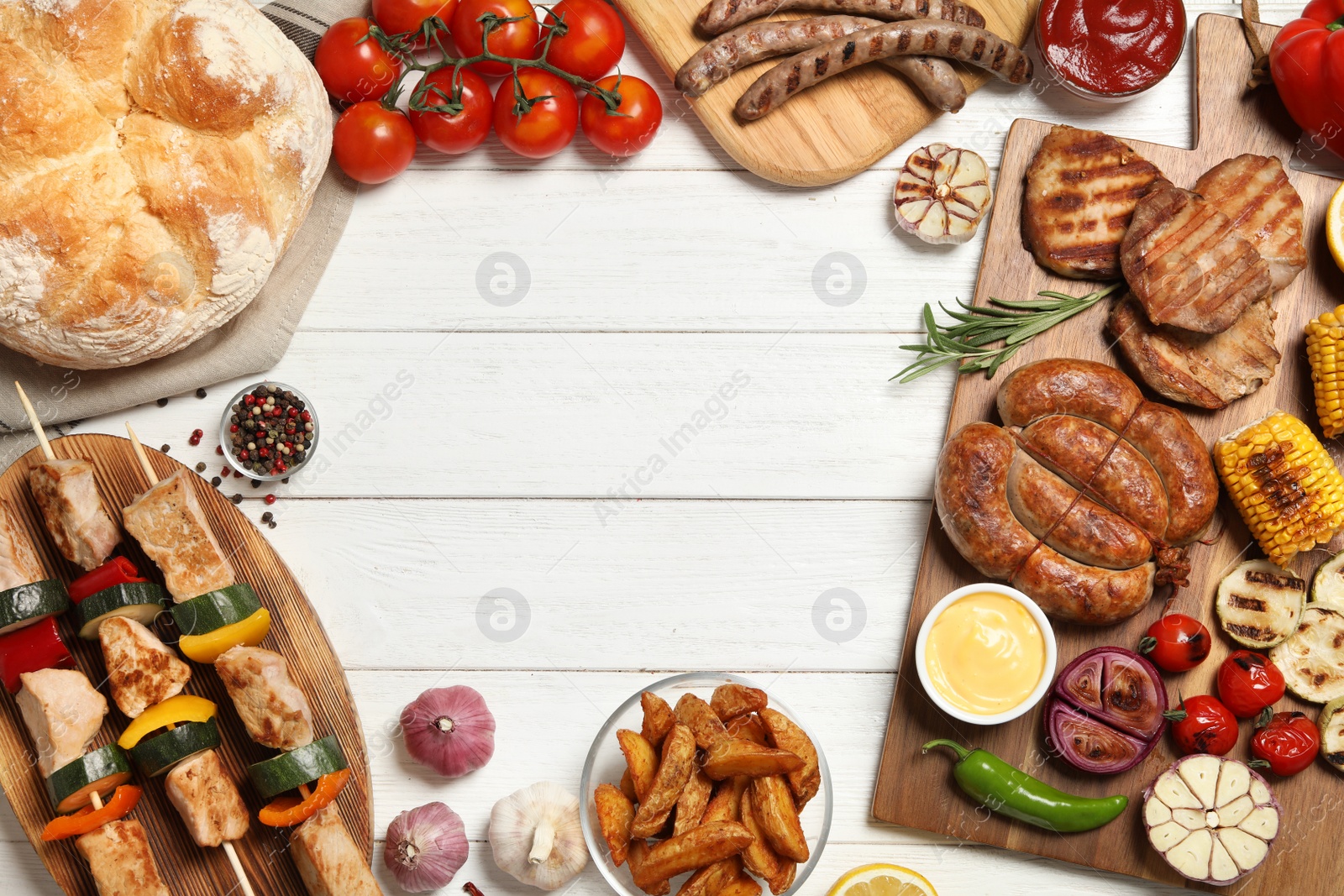 Photo of Frame of barbecued meat and vegetables on white wooden table, flat lay. Space for text