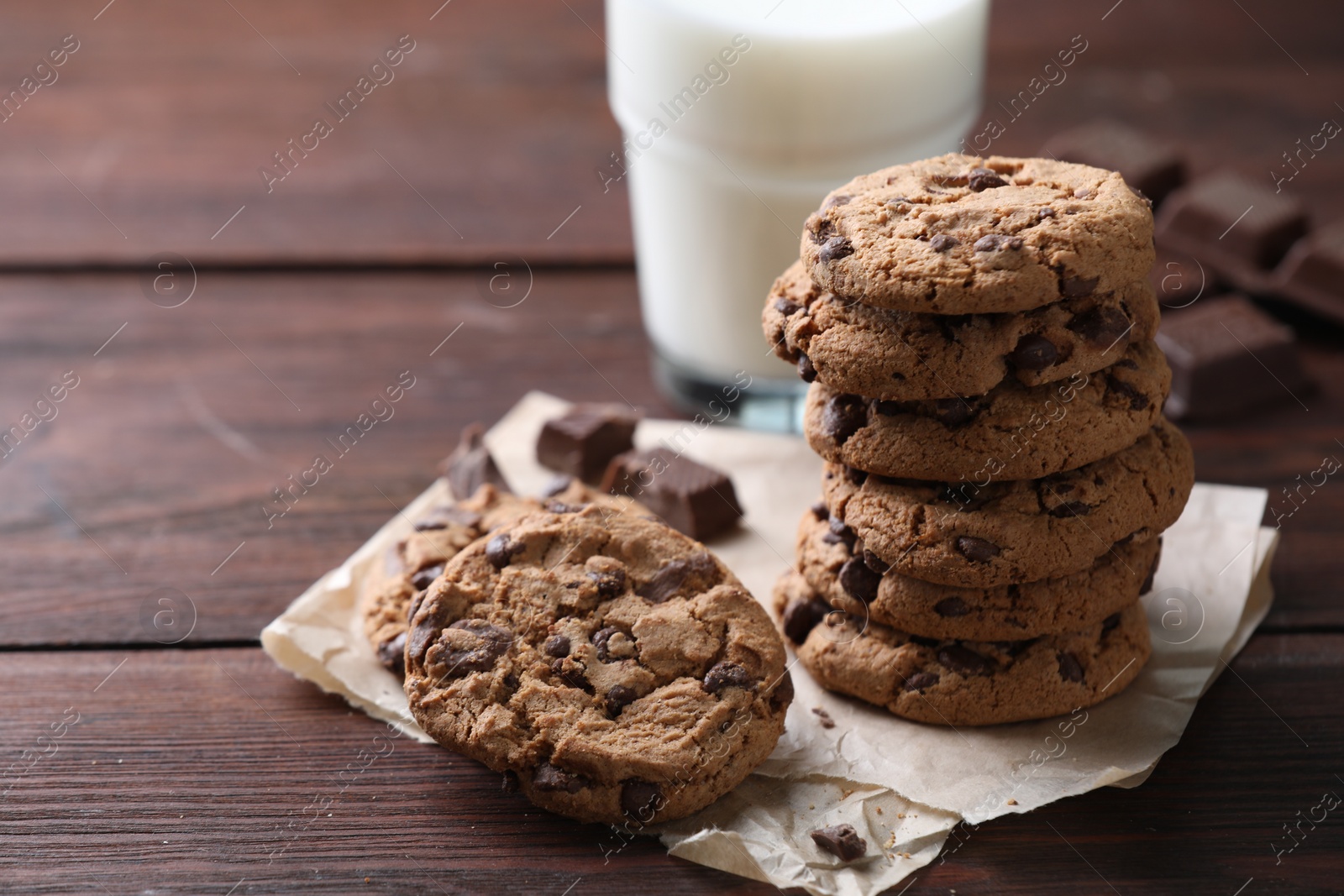 Photo of Delicious chocolate chip cookies on wooden table, space for text