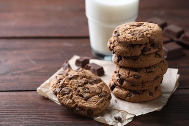 Photo of Delicious chocolate chip cookies on wooden table, space for text