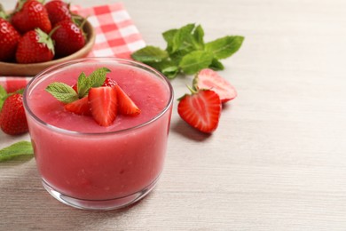 Delicious strawberry mousse with mint on white wooden table, space for text