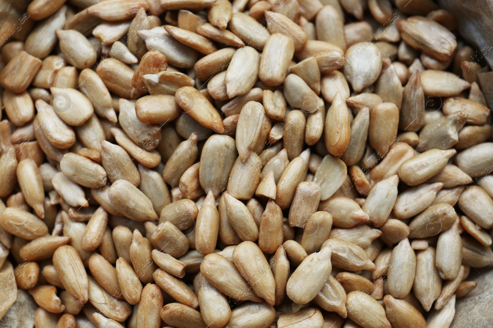 Photo of Pile of peeled sunflower seeds as background, closeup