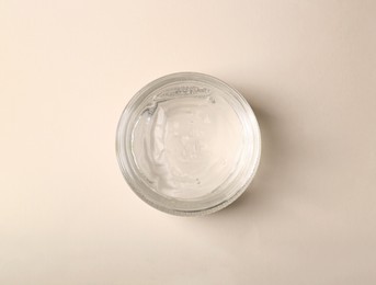 Jar of aloe gel on beige background, top view