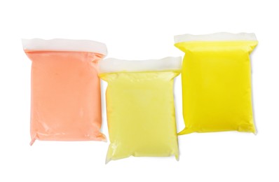 Photo of Packages of colorful play dough on white background, top view