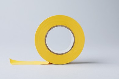 Photo of Yellow insulating tape on light grey background. Electrician's supply