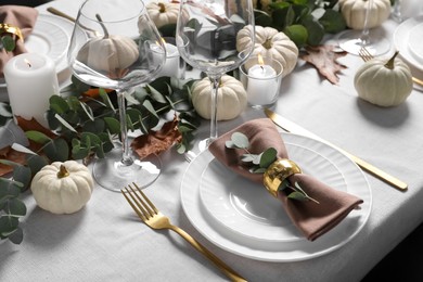 Photo of Beautiful autumn table setting. Plates, cutlery, glasses, pumpkins and floral decor