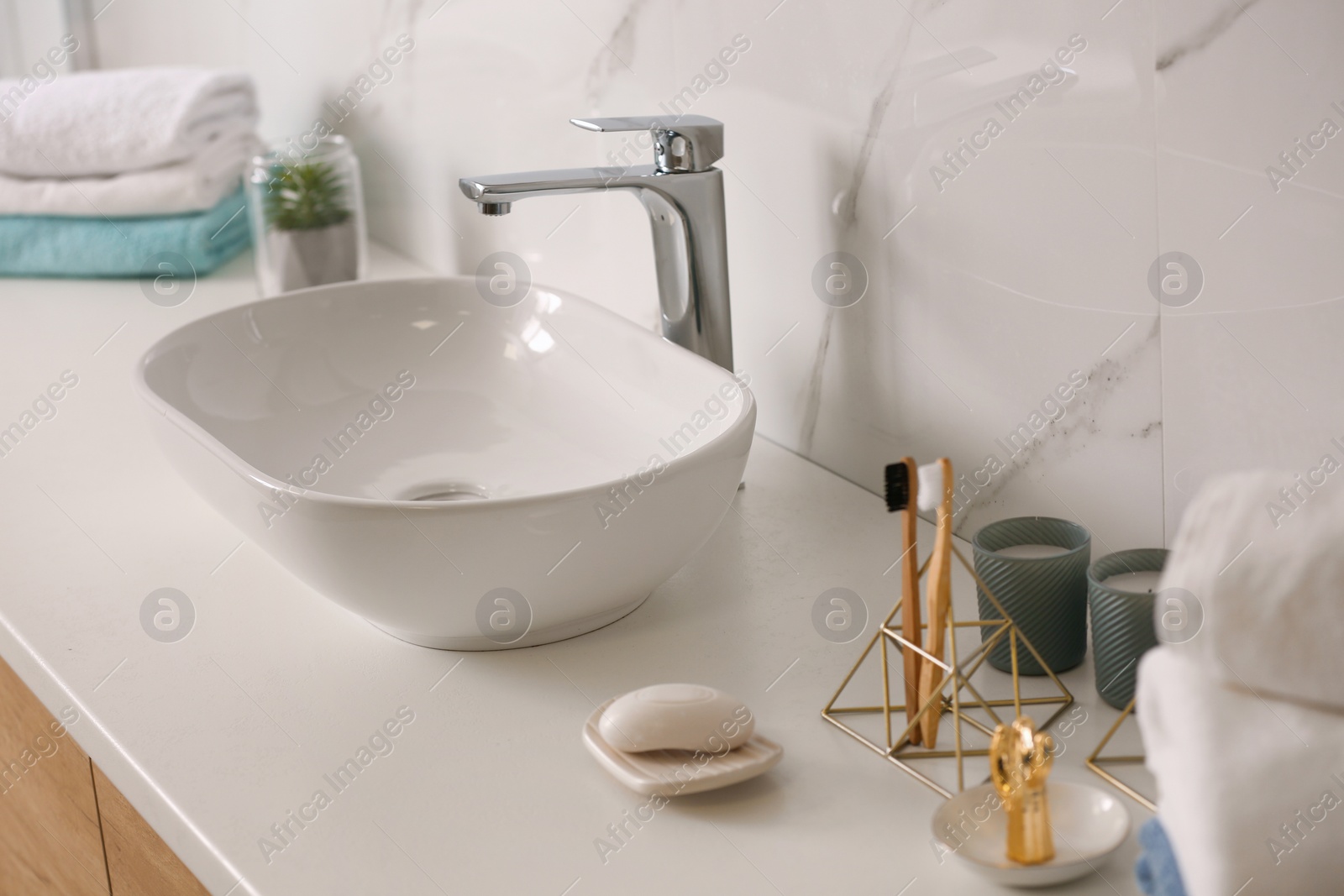 Photo of Stylish vessel sink on light countertop in modern bathroom