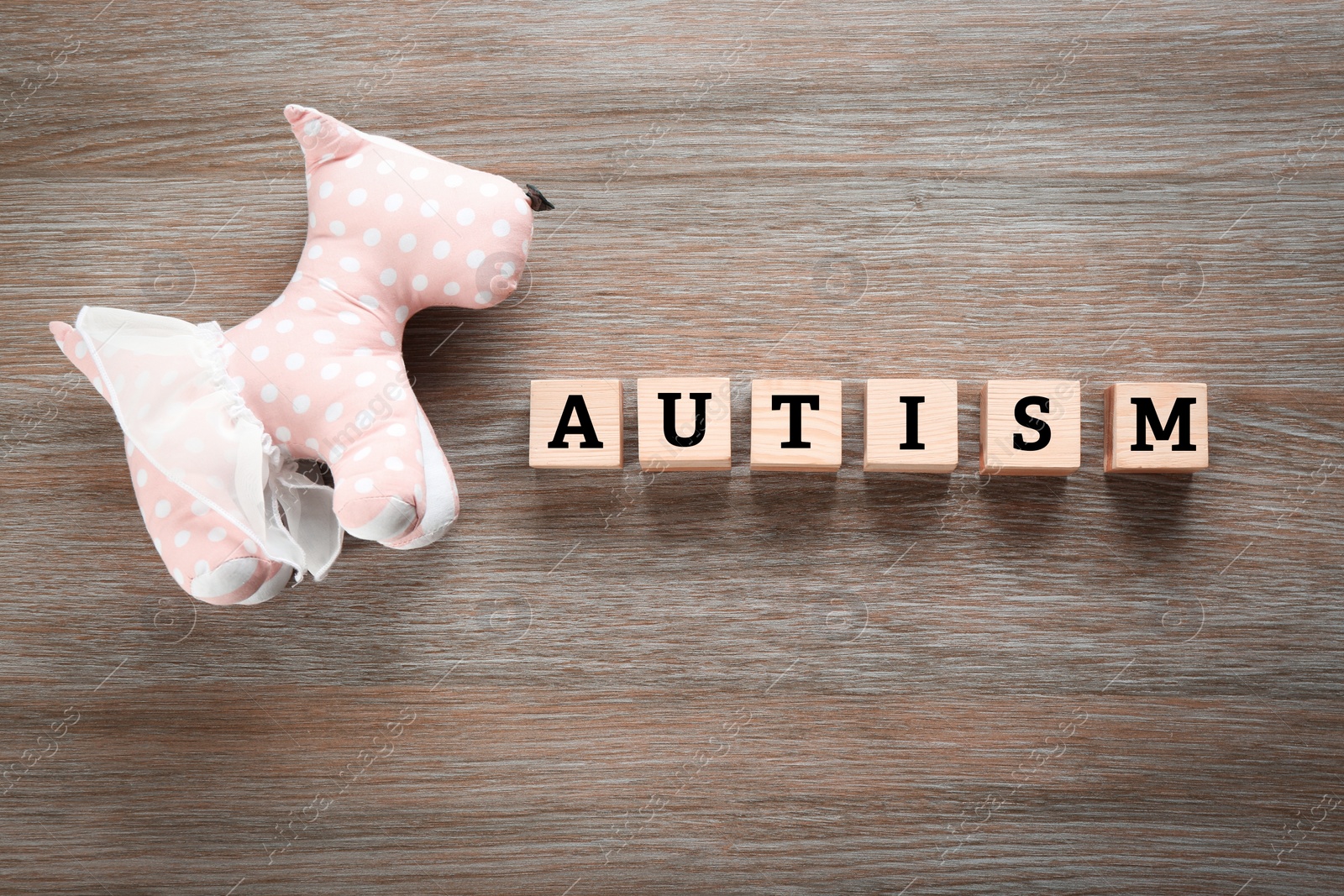 Photo of Toy and cubes with word "Autism" on wooden background