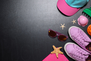 Photo of Flat lay composition with child's shoes on blackboard, space for text. School holidays