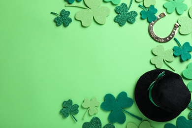 Flat lay composition with leprechaun hat on light green background, space for text. St. Patrick's Day celebration
