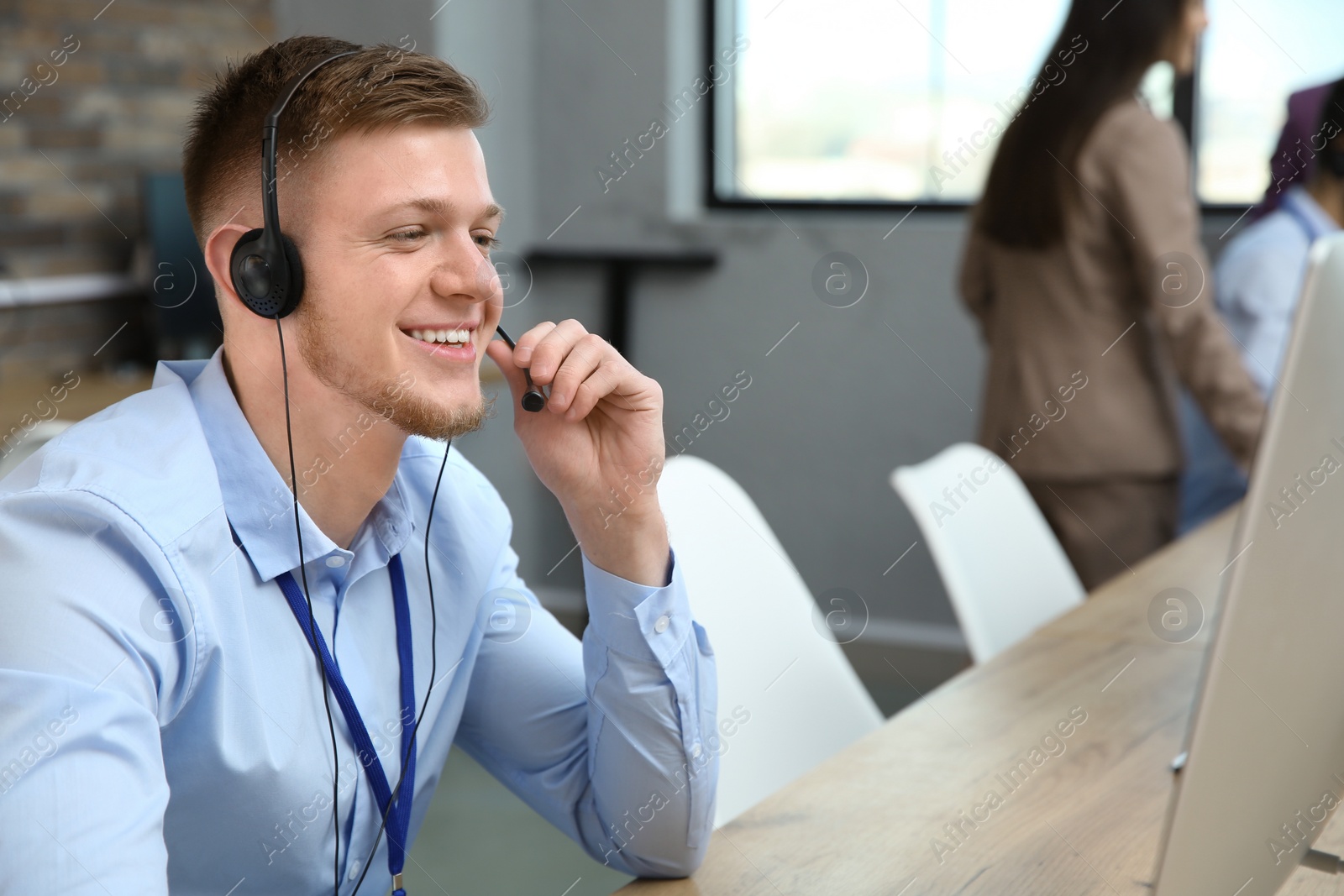 Photo of Technical support operator with headset working in office