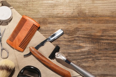 Photo of Moustache and beard styling tools on wooden table, flat lay. Space for text