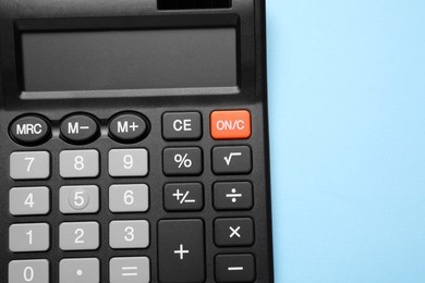 Calculator on light blue background, top view. Space for text