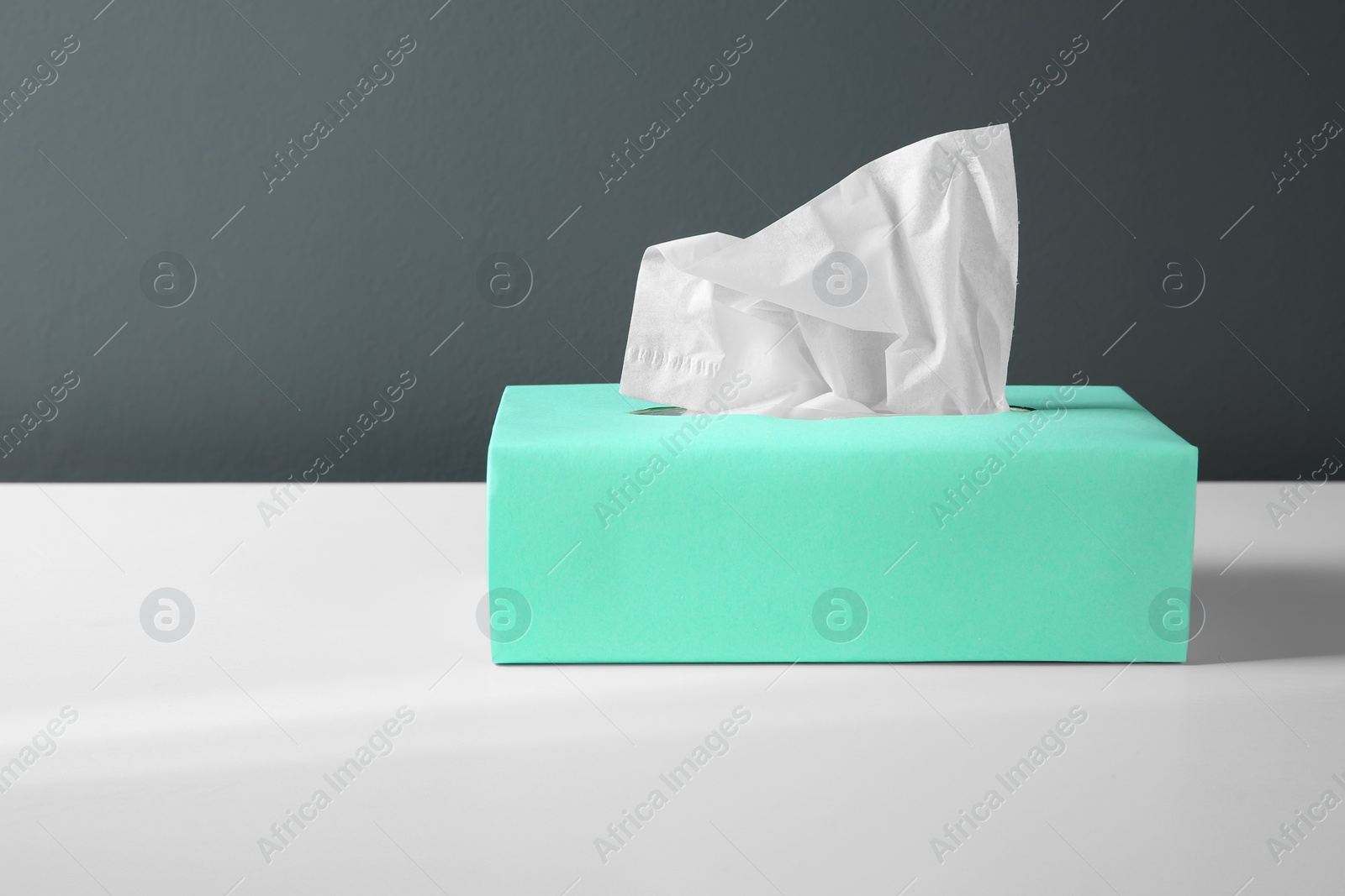 Photo of Box with paper tissues on white table