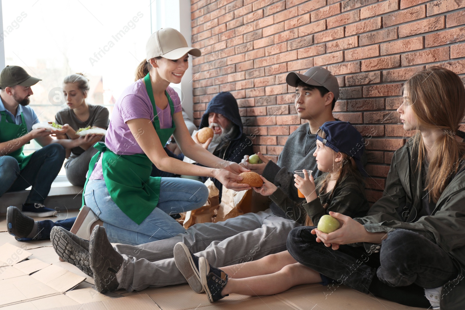 Photo of Volunteers giving food to poor people indoors