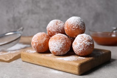 Delicious sweet buns with powdered sugar on gray table
