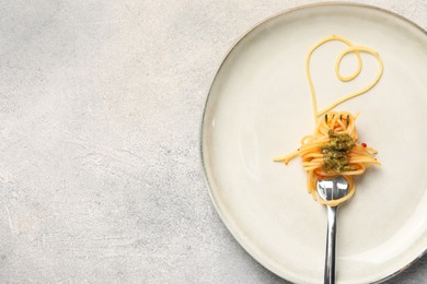 Photo of Heart made with spaghetti and fork on grey table, top view. Space for text