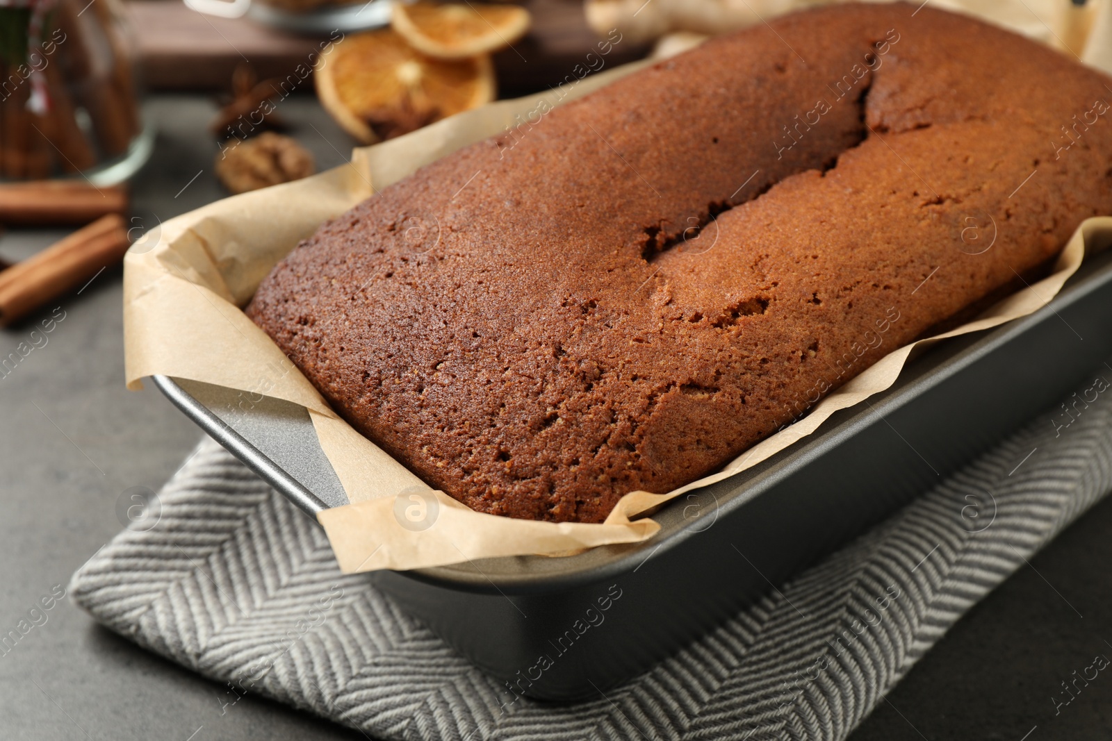 Photo of Delicious gingerbread cake in baking dish on grey table, closeup