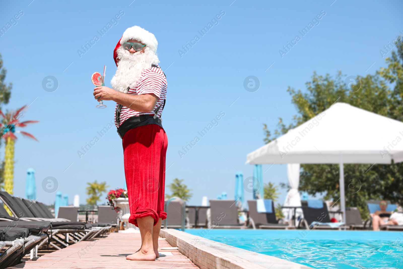 Photo of Authentic Santa Claus with cocktail near pool at resort