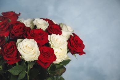 Photo of Luxury bouquet of fresh roses on light blue background, closeup