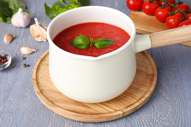 Photo of Delicious tomato sauce on grey wooden table