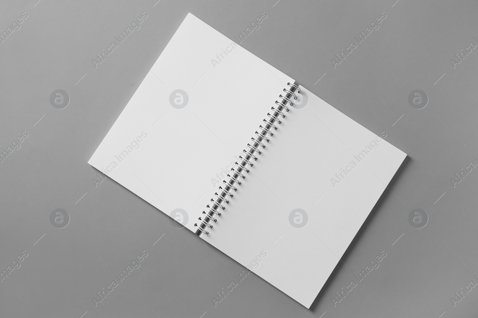 Photo of Open blank notebook on grey background, top view. Mockup for design