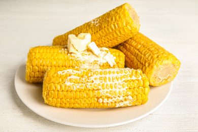 Delicious boiled corn with butter on white wooden table