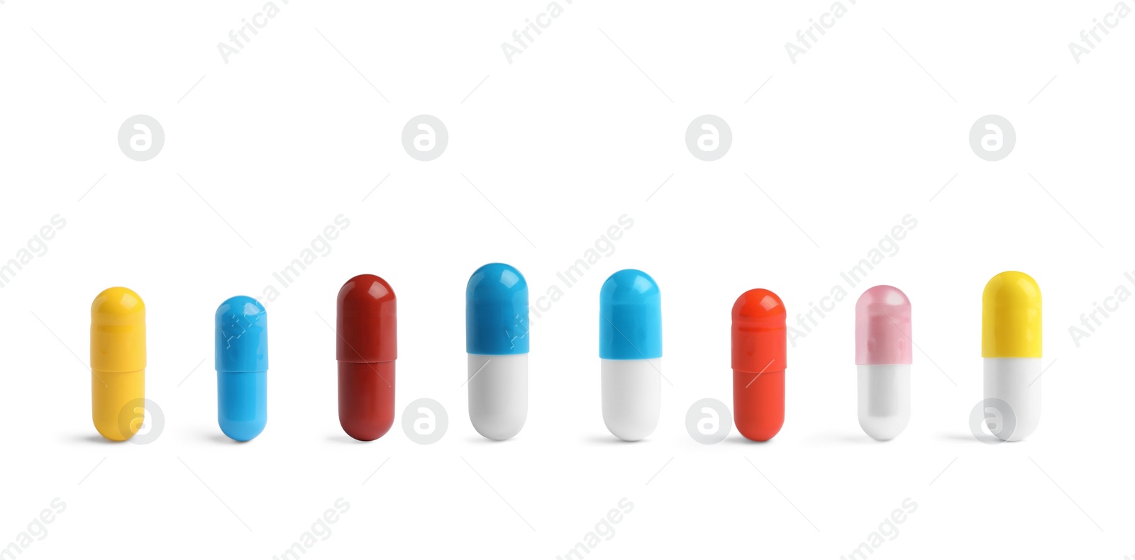 Image of Set of different color pills in row isolated on white