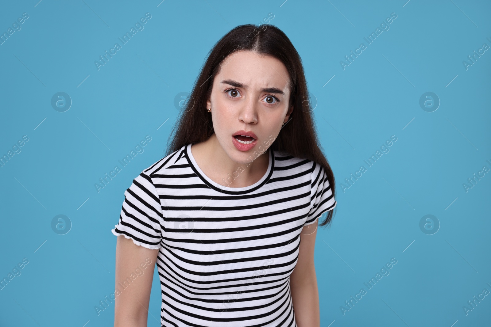 Photo of Portrait of surprised woman on light blue background