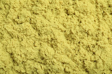 Yellow kinetic sand as background, closeup view