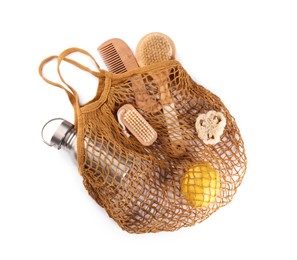 Photo of Fishnet bag with different items isolated on white, top view. Conscious consumption