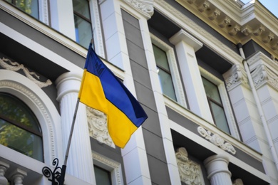 Photo of National flag of Ukraine on vintage building wall outdoors