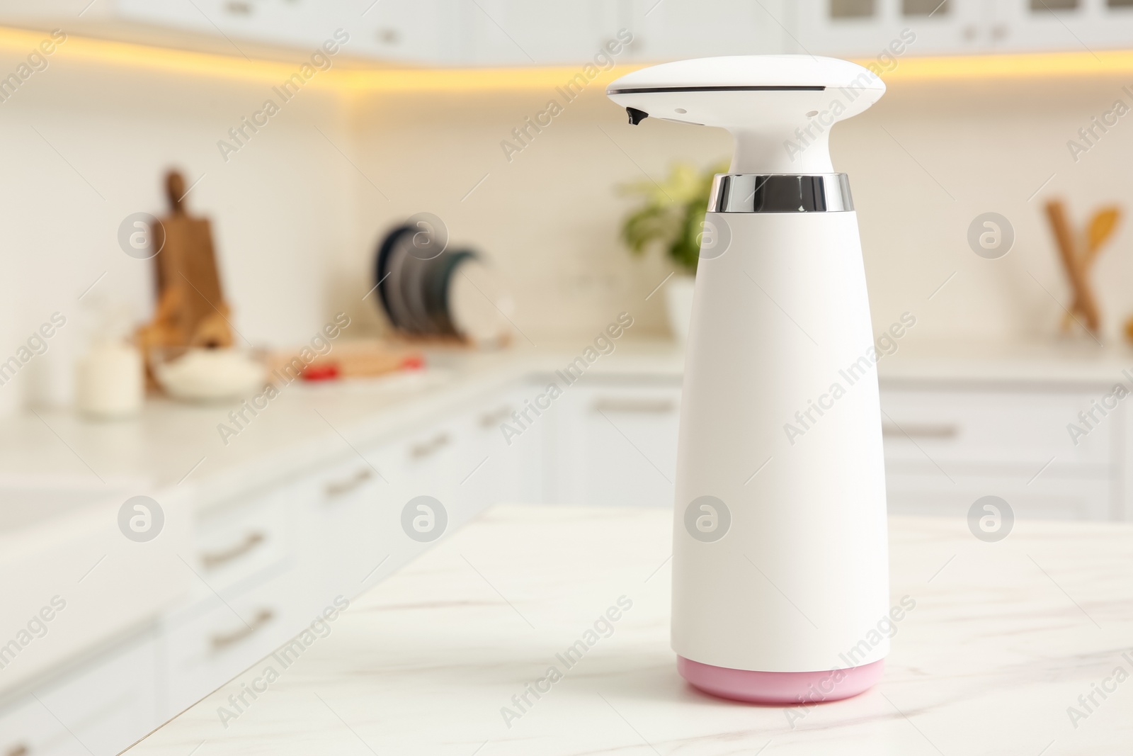 Photo of Modern automatic soap dispenser on countertop in kitchen. Space for text