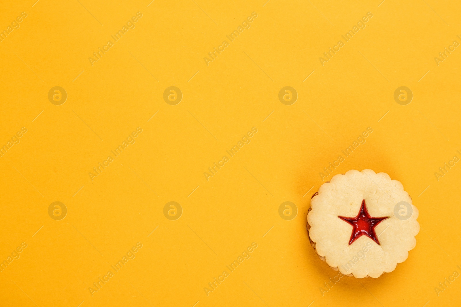 Photo of Traditional Christmas Linzer cookie with sweet jam on color background, top view