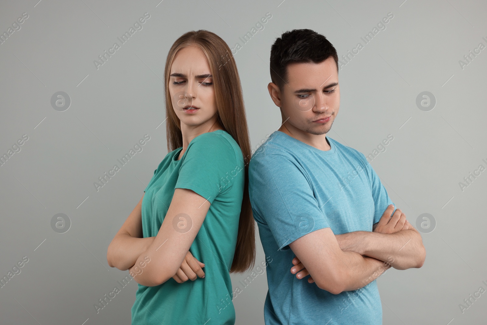 Photo of Portrait of resentful couple with crossed arms on grey background