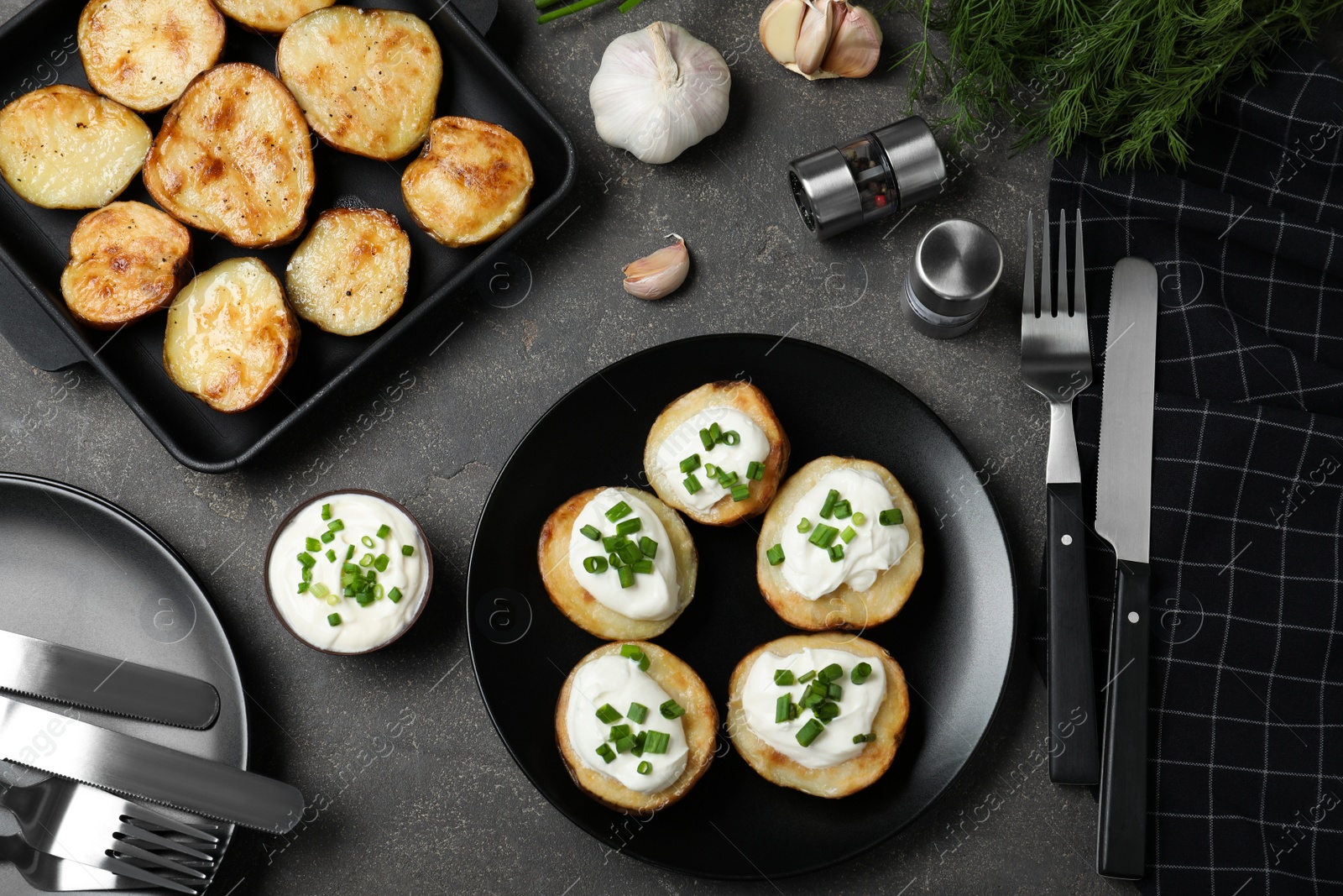 Photo of Delicious potato wedges with sour cream dressing on grey table, flat lay