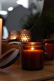 Lit candles on wooden dressing table indoors